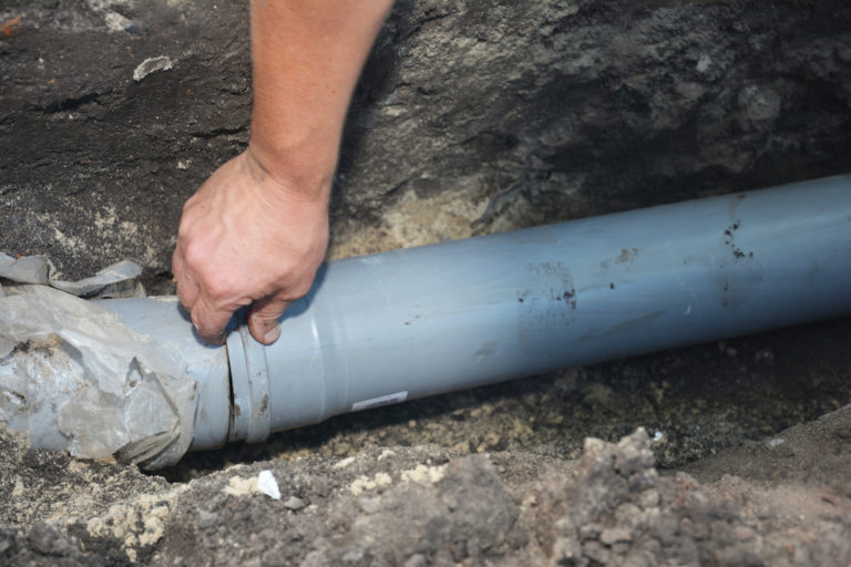 Crew installing sewer pipe in a trench
