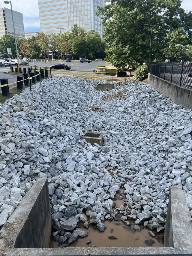 Stone-lined retention pond with outlet structure at a commercial property